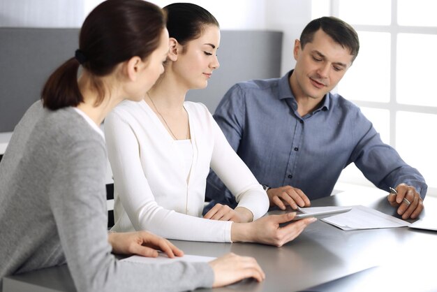 Groupe de gens d'affaires discutant de questions lors d'une réunion dans un bureau moderne. Headshot à la négociation ou au travail. Travail d'équipe, partenariat et concept d'entreprise.