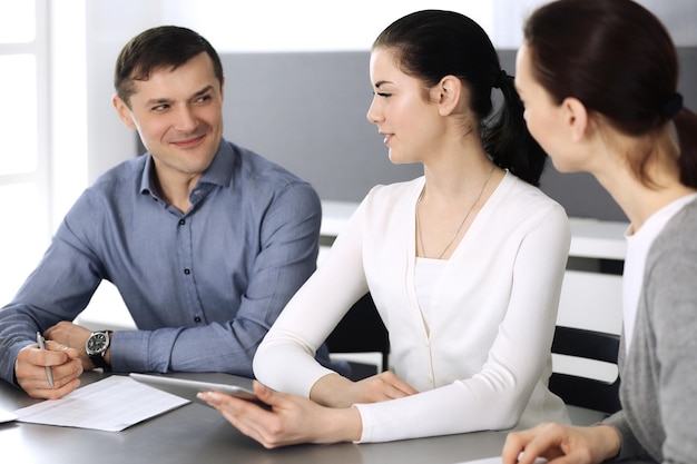 Groupe de gens d'affaires discutant de questions lors d'une réunion dans un bureau moderne. Headshot à la négociation ou au travail. Travail d'équipe, partenariat et concept d'entreprise.