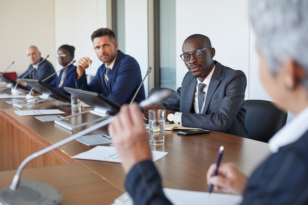 Groupe de gens d'affaires à l'écoute de l'orateur lors d'une réunion d'affaires au bureau