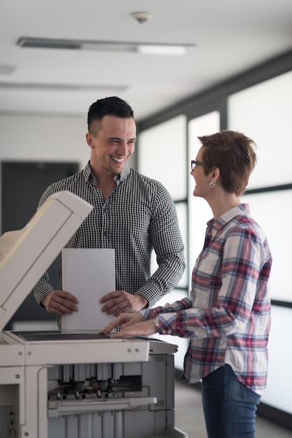 groupe de gens d'affaires heureux au bureau moderne copier des documents sur la machine