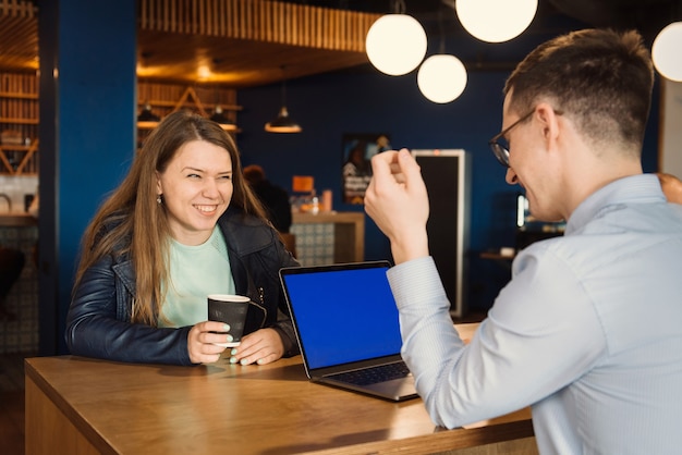 Groupe de gens d'affaires heureux ayant une discussion au bureau autour d'une tasse de café