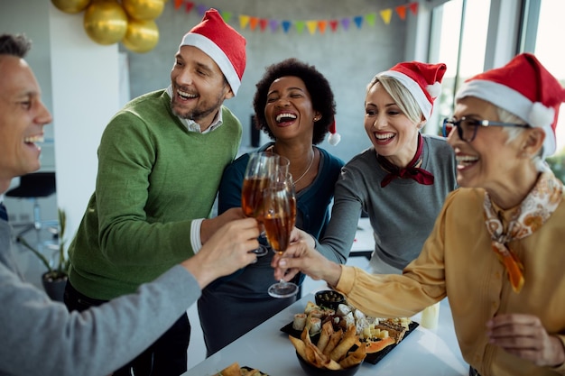 Photo groupe de gens d'affaires heureux portant un toast et s'amusant à la fête de noël au bureau