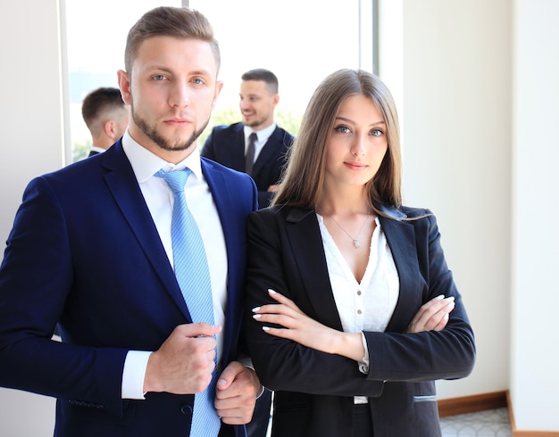 Groupe de gens d'affaires lors d'une réunion sur le fond du bureau. Focus sur un beau brun