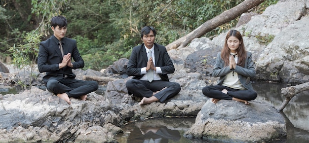 Groupe de gens d'affaires de la méditation à la livre de l'eau.