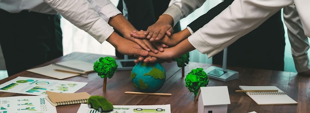 Photo un groupe de gens d'affaires met la main sur une pile montrant la synergie de la coopération des entreprises en matière de protection de l'environnement pour sauver la terre. sensibilisation à l'environnement et concept d'unité écologique. pionnier