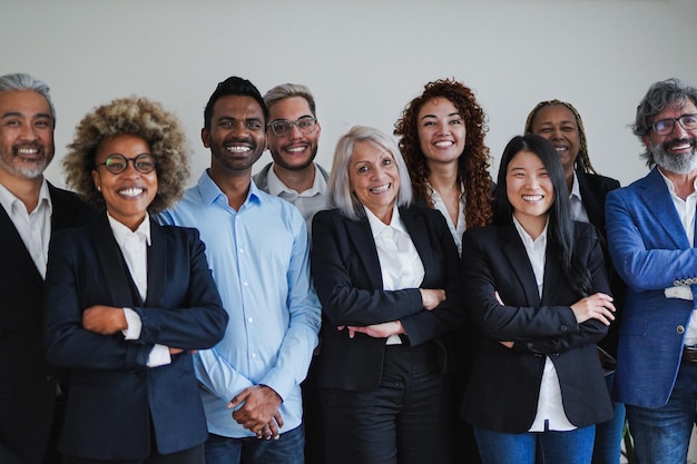 Groupe de gens d'affaires multiethniques heureux souriant à la caméra à l'intérieur du bureau