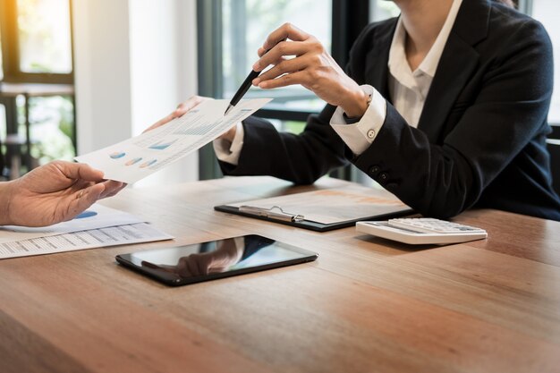 Groupe de gens d&#39;affaires prospères qui discute de la paperasserie et de l&#39;utilisation d&#39;un ordinateur portable ensemble, du travail d&#39;équipe et du concept de brainstorming.