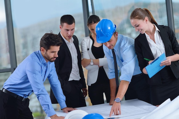 Photo groupe de gens d'affaires sur la réunion et la présentation dans un bureau moderne et lumineux avec un architecte ingénieur en construction et un travailleur à la recherche de modèles de construction et de plans directeurs