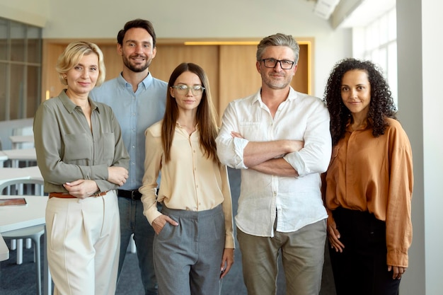 Groupe de gens d'affaires souriants et confiants, collègues, travailleurs regardant la caméra dans un bureau moderne