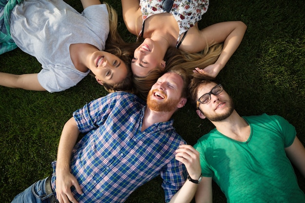 Groupe de gens heureux allongé sur l'herbe