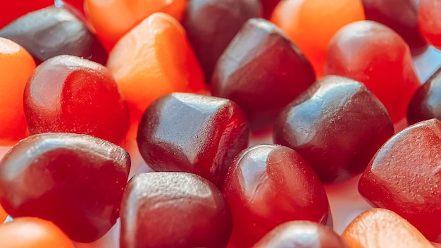 Groupe de gommes multivitamines rouge orange et violet gros plan sur fond blanc Mode de vie sain