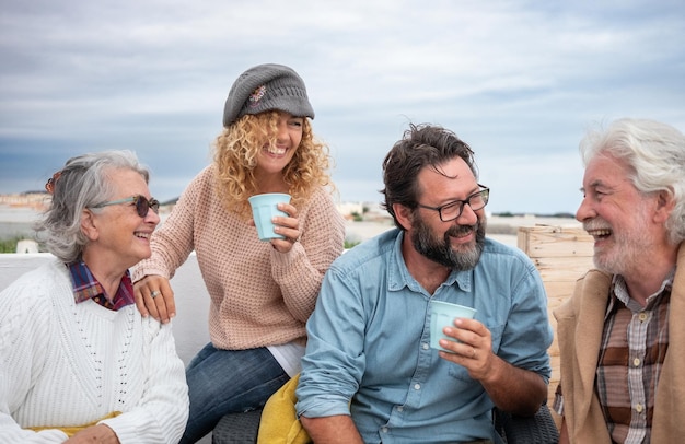 Un groupe heureux de familles multi-générations a passé du temps ensemble sur la terrasse. Couple de personnes âgées et fils