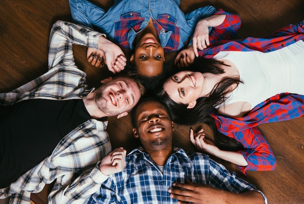 Groupe heureux de quatre jeunes amis noirs et blancs, passe-temps ensemble