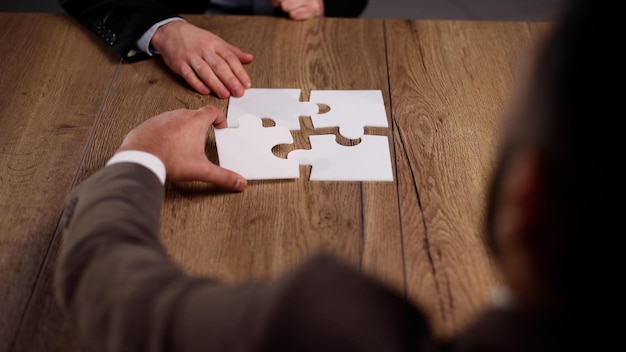 Groupe d'hommes d'affaires assemblant un puzzle sur une table