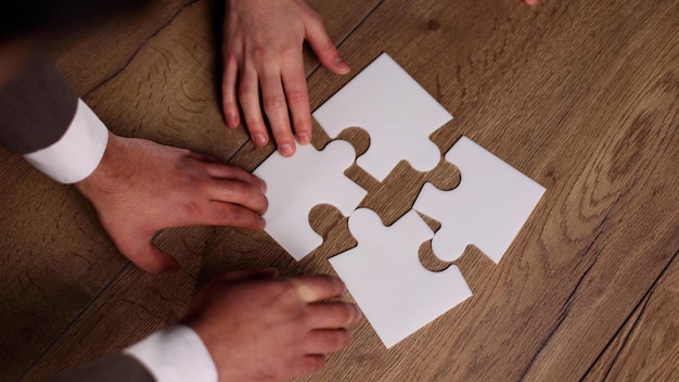 Groupe d'hommes d'affaires assemblant un puzzle sur une table