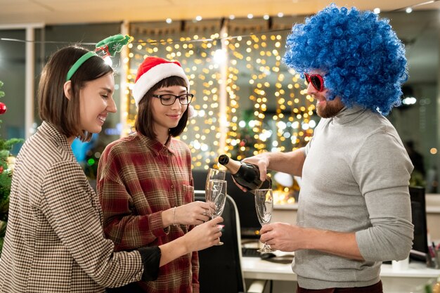 Groupe d'hommes d'affaires célébrant Noël au bureau et va avoir du champagne pour les vacances