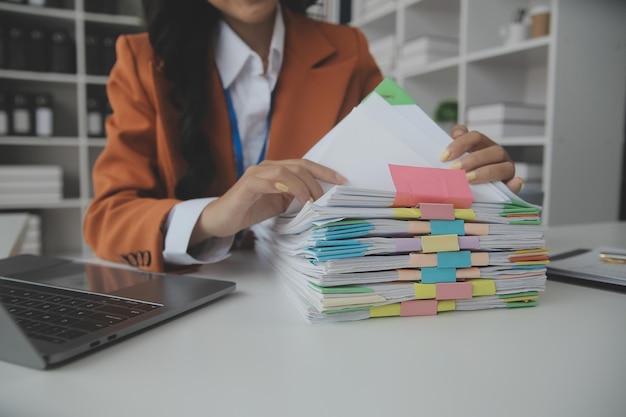 Un groupe d'hommes d'affaires confiants pointe vers des graphiques et des tableaux pour analyser le bénéfice net du compte de bilan des données du marché afin de planifier de nouvelles stratégies de vente pour augmenter la capacité de production