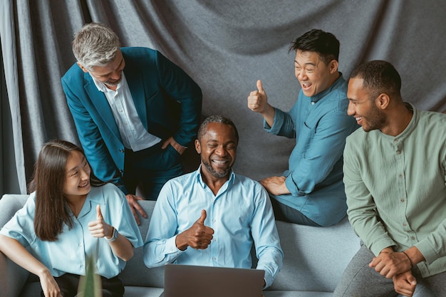 Groupe d'hommes d'affaires multiethniques travaillant ensemble sur un projet assis dans un bureau moderne