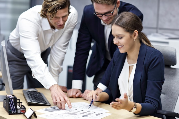 Groupe d'hommes d'affaires partageant des idées dans un bureau moderne