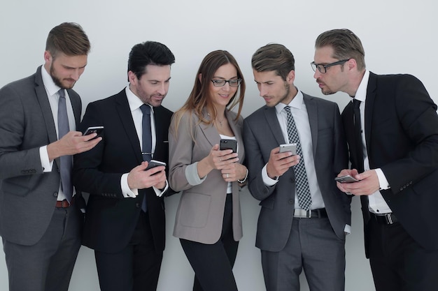 Groupe d'hommes d'affaires regardant les écrans de leurs smartphones et de la technologie