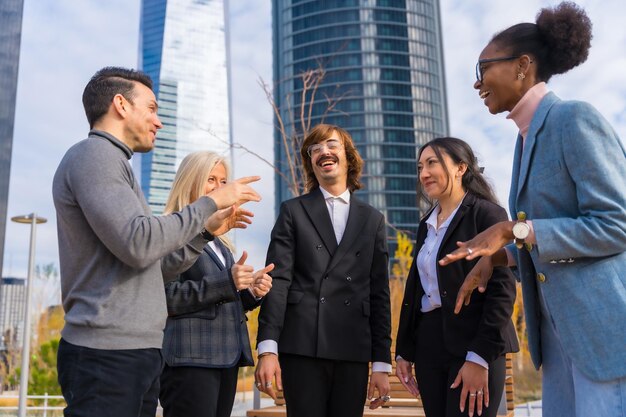 Groupe d'hommes et de femmes d'affaires multiethniques d'âge moyen dans un parc d'affaires se parlant