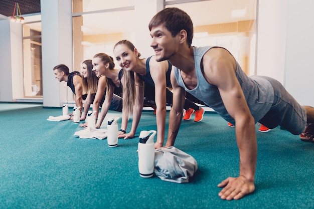 Groupe hommes et femmes effectue un exercice physique.