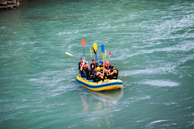 Un groupe d'hommes et de femmes font du rafting sur la rivière, sport extrême et amusant