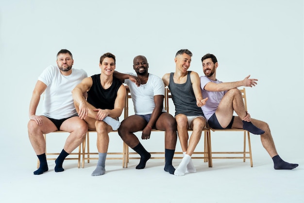 Groupe d'hommes multiethniques posant pour un ensemble de beauté positive pour le corps masculin. Gars torse nu avec un âge différent et un corps portant des sous-vêtements de boxeurs