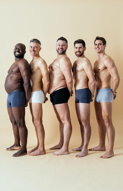 Groupe d'hommes multiethniques posant pour un ensemble de beauté positive pour le corps masculin. Gars torse nu avec un âge différent et un corps portant des sous-vêtements de boxeurs