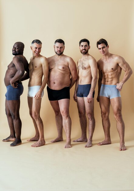 Groupe d'hommes multiethniques posant pour un ensemble de beauté positive pour le corps masculin. Gars torse nu avec un âge différent et un corps portant des sous-vêtements de boxeurs