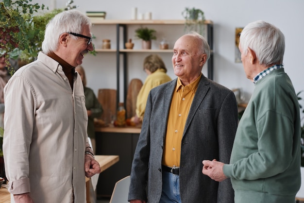 Groupe d'hommes seniors en costume se parlant pendant leur réunion