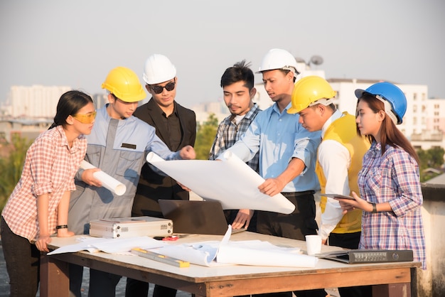 Groupe d&#39;ingénieurs et d&#39;architectes discute sur un chantier de construction