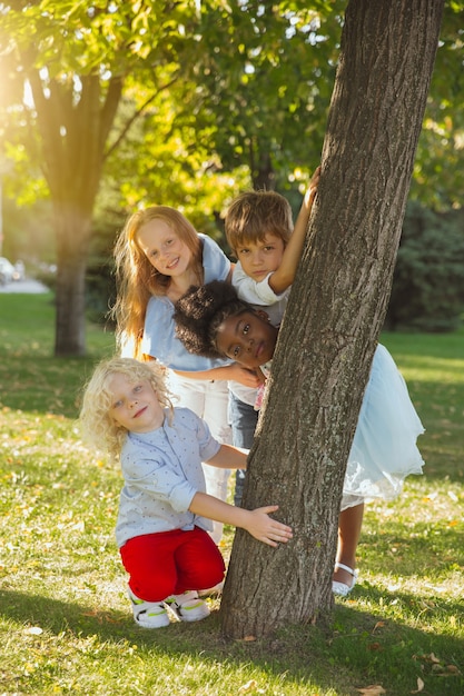 Photo groupe interracial d'enfants filles et garçons jouant ensemble au parc