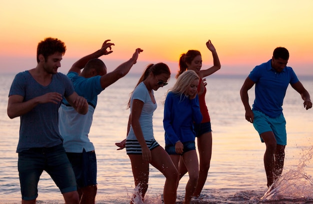 Groupe de jeunes adultes faisant la fête à la plage