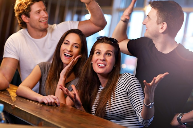 Groupe de jeunes amis appréciant le repas au restaurant