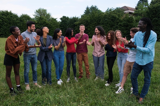 Groupe de jeunes amis de différentes cultures applaudissant et dansant ensemble