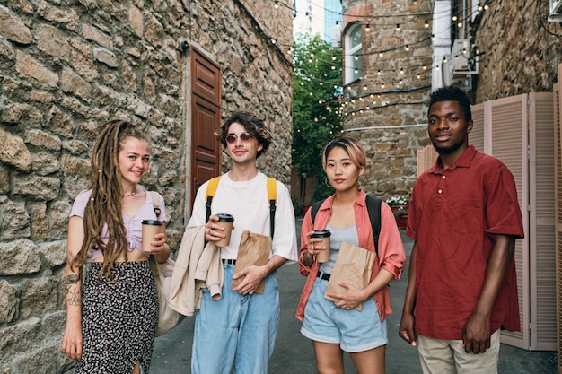 Groupe de jeunes amis interculturels avec boissons et collations