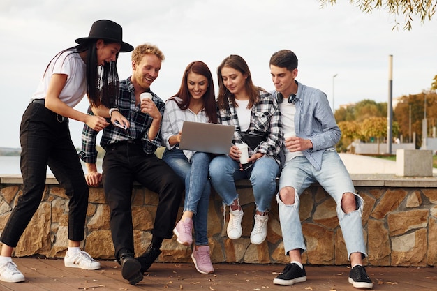 Groupe de jeunes amis joyeux qui s'amusent ensemble à l'extérieur