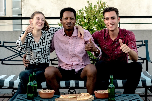 Groupe de jeunes amis avec pizza et bouteilles de boisson