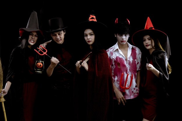 Groupe de jeunes asiatiques en costume Halloween party sur fond noir avec concept pour Halloween fashion festival en studio. Gang d'adolescents asiatiques en cosplay Halloween. Costume fantôme, mal du groupe ado thaï.
