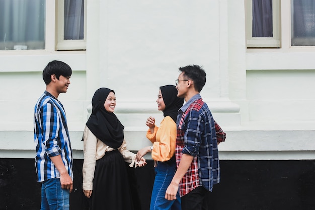 Groupe de jeunes asiatiques souriant et parlant ensemble