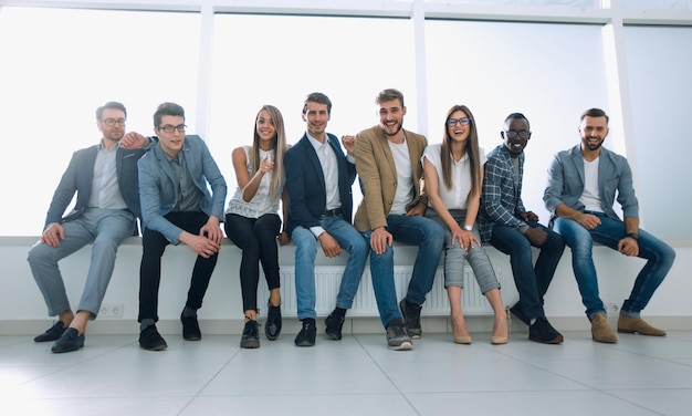 Groupe de jeunes assis dans le hall du bureau photo avec espace de copie