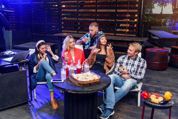 Groupe de jeunes assis et mangeant de la pizza. Amis faire la fête et manger de la pizza.