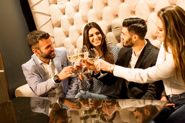 Groupe de jeunes célébrant et grillant avec du vin blanc