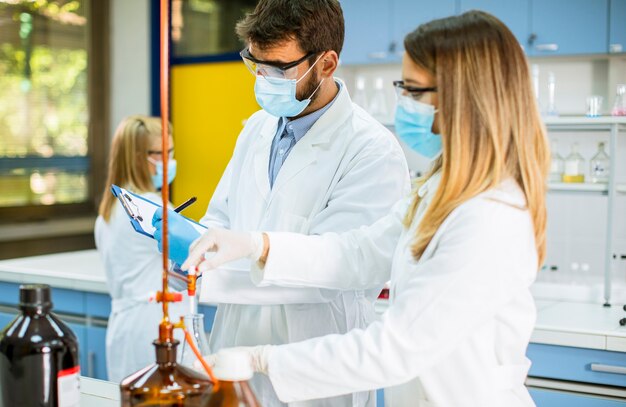 Groupe de jeunes chercheurs analysant des données chimiques en laboratoire