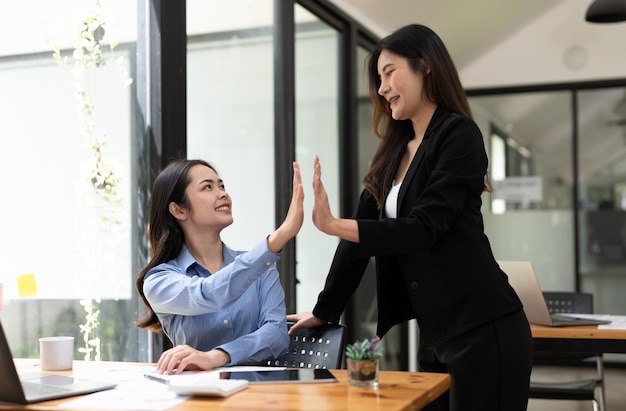 Groupe de jeunes collègues d'affaires créatifs de l'équipe d'affaires asiatiques au bureau Heureux d'être un travail d'équipe de partenariat réussi célébrant la réussite et le concept de réussite