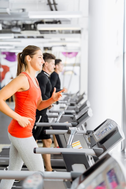 Groupe de jeunes courant sur des tapis roulants dans un centre de remise en forme