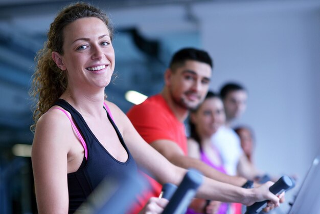 groupe de jeunes courant sur des tapis roulants dans une salle de sport moderne