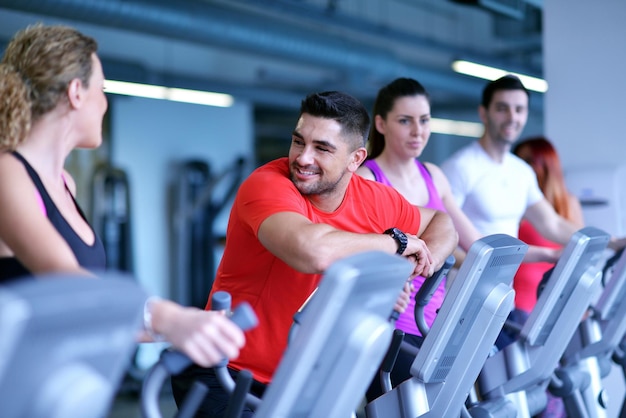 groupe de jeunes courant sur des tapis roulants dans une salle de sport moderne