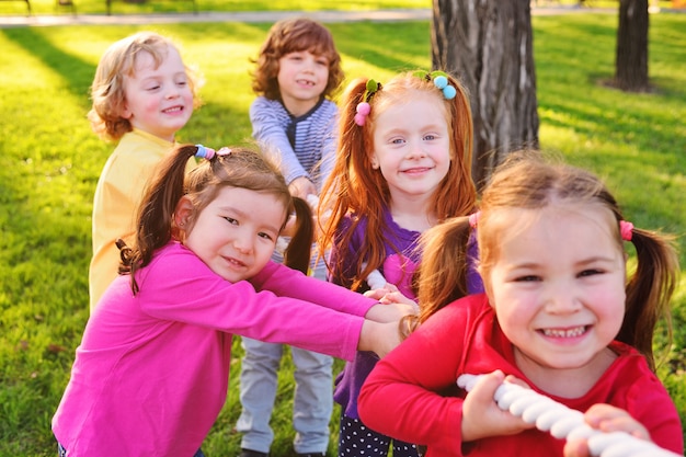 Un groupe de jeunes enfants d&#39;âge préscolaire joue un bras de fer dans le parc.